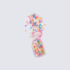 One small glass jar filled with assorted colorful sprinkles